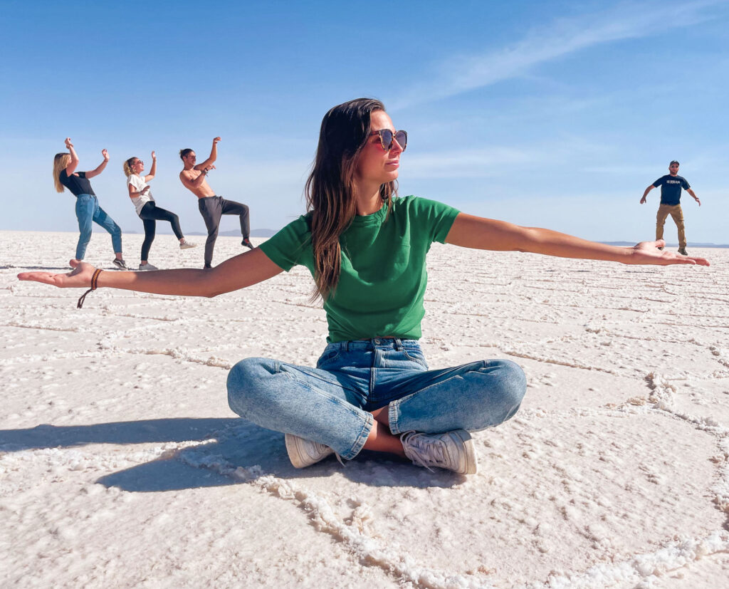Group of travelers playing with perspective in Salar de Uyuni, Bolivia.