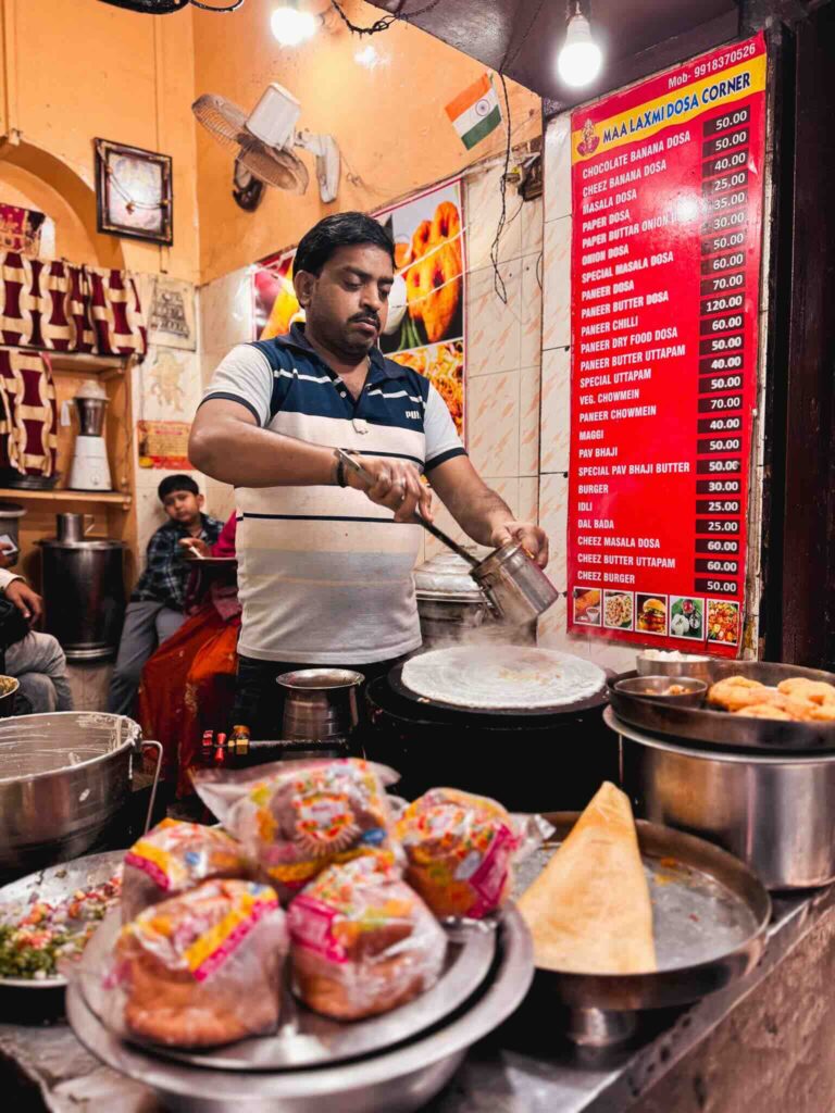 Street food in Benares with a vendor serving traditional lassi.
