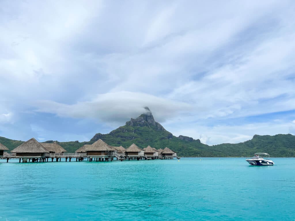 Lagon de Bora Bora avec bungalows sur pilotis et montagne en arrière-plan.