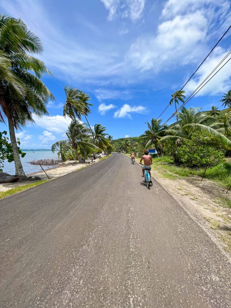 Laurent à vélo à Bora Bora, Polynésie française, avec lagon et paysages tropicaux.