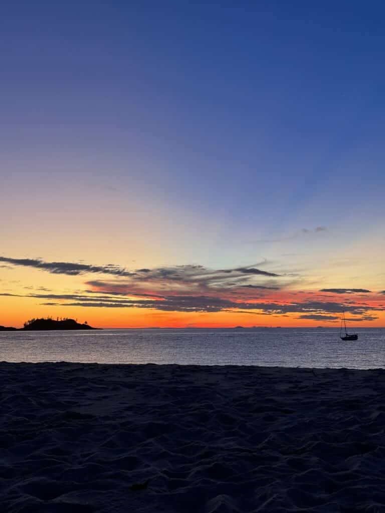 Coucher de soleil sur l’horizon depuis une plage d’une île des Whitsundays.