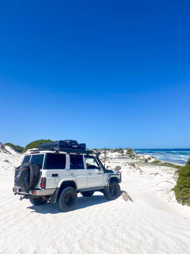 Land Cruiser dans le sable face à la mer, près de Wedge Island, dans le Western Australia.