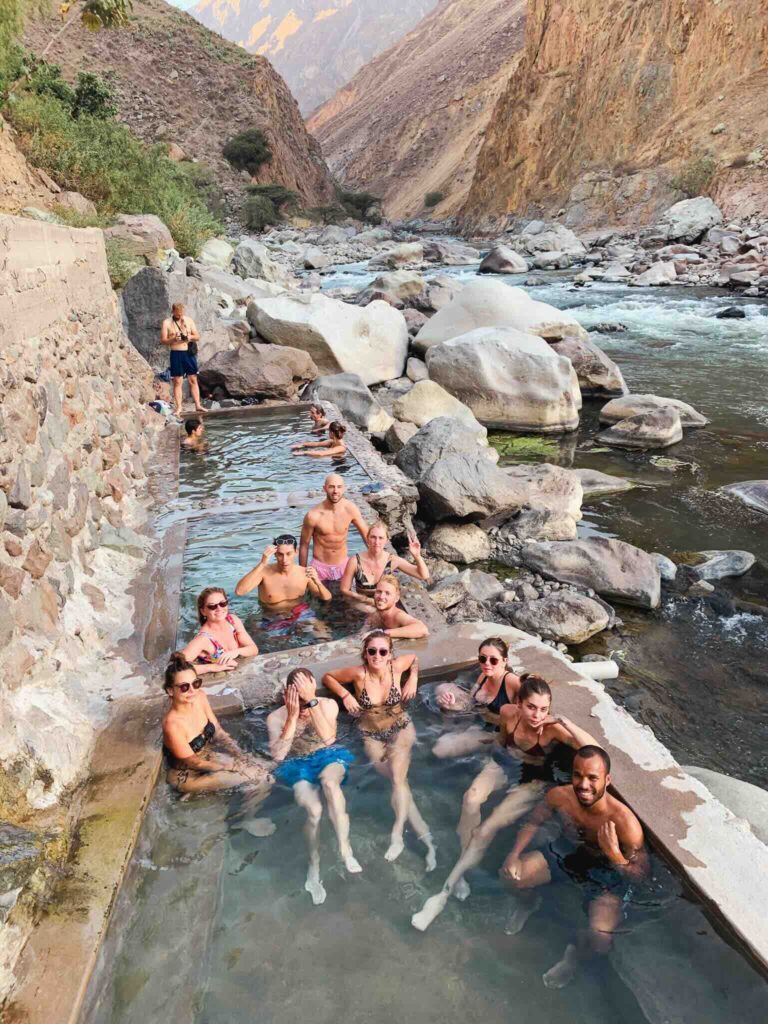 Group of friends enjoying a natural pool during a Colca Canyon trek, Peru.