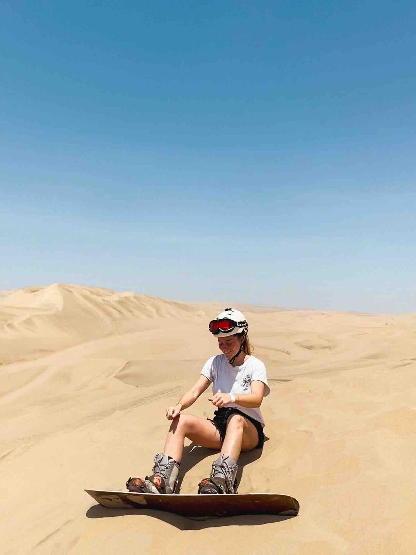 Sandboarding on the golden dunes of Huacachina, Peru – a unique experience during a Peruvian adventure.