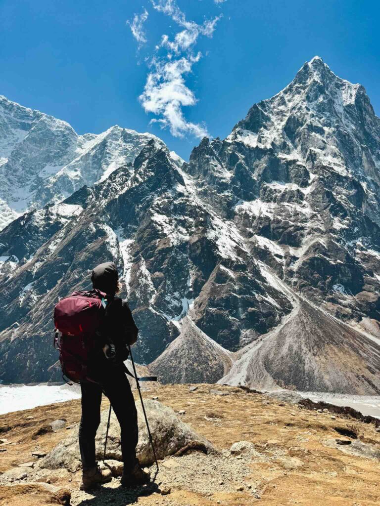 Person seen from behind facing Taboche peak in the Nepalese Himalayas, during the Three Passes Trek, Nepal.