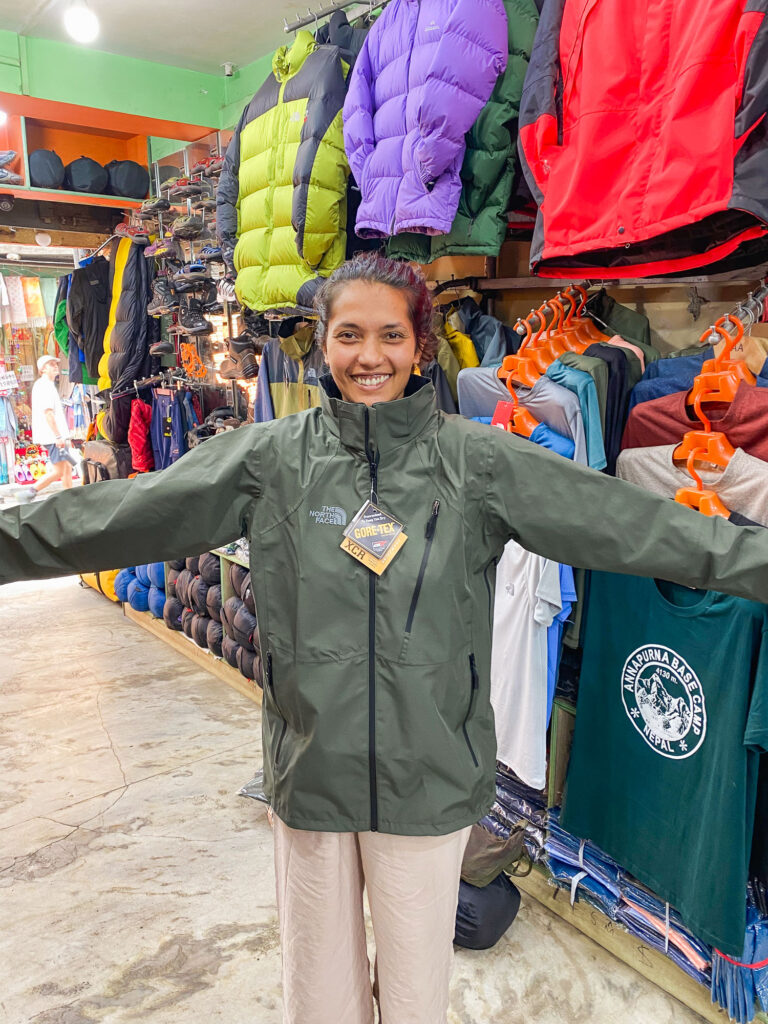 Trying on jackets and trekking gear in a Kathmandu store before starting the Three Passes Trek, Nepal.