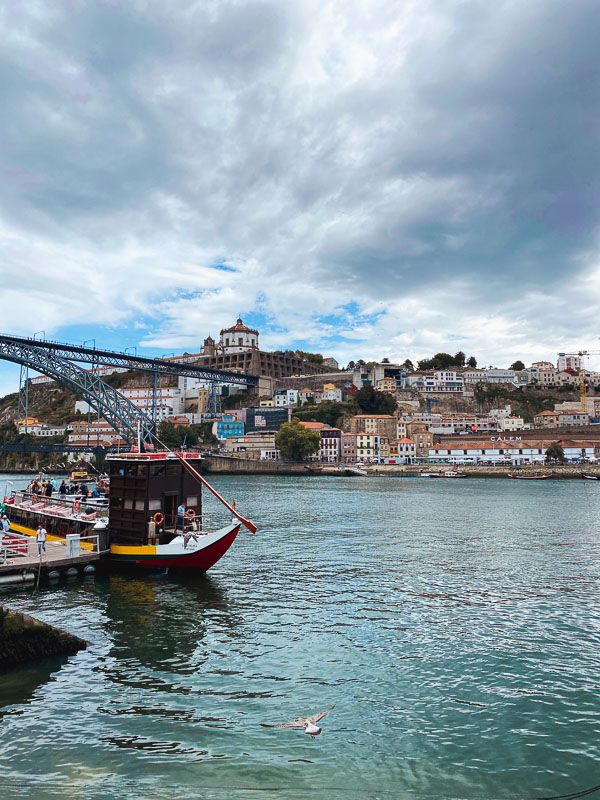A boat on the water in the São Nicolau district of Porto, with buildings in the background during a Spain-Portugal road trip.