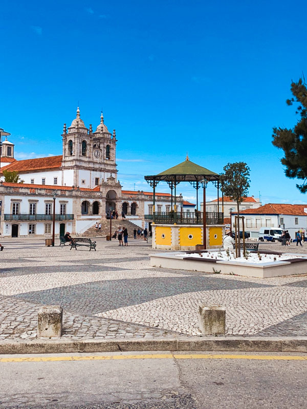 Small square in the village of Nazaré with its church, Portugal.