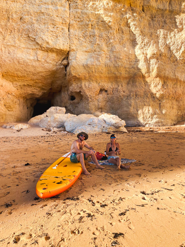 Picnic on a beach near the Benagil caves, with ocean views and a stand-up paddle board.