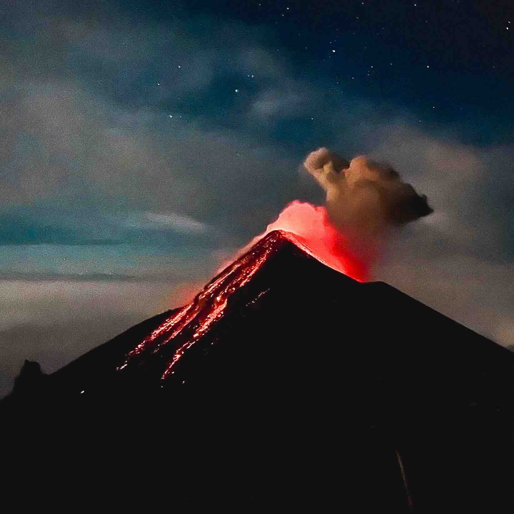 Night eruption of El Fuego volcano in Guatemala with lava bursts lighting up the dark sky
