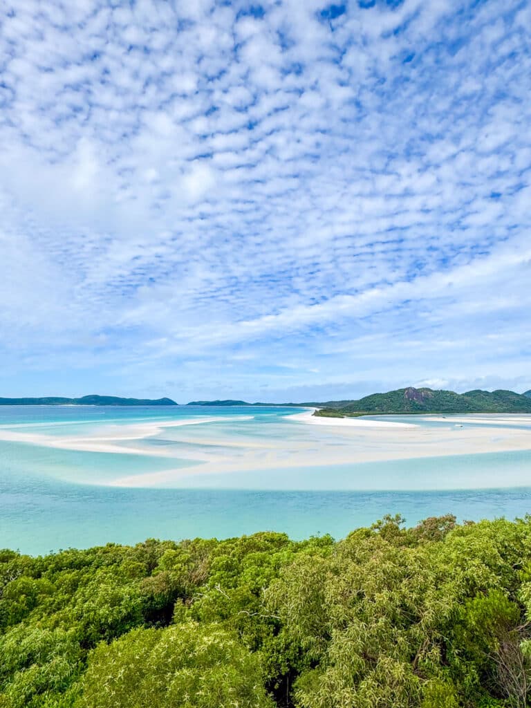 Plage de Whitehaven Beach, avec sable blanc, eau turquoise et végétation tropicale en arrière-plan, Whitsundays, Australie.