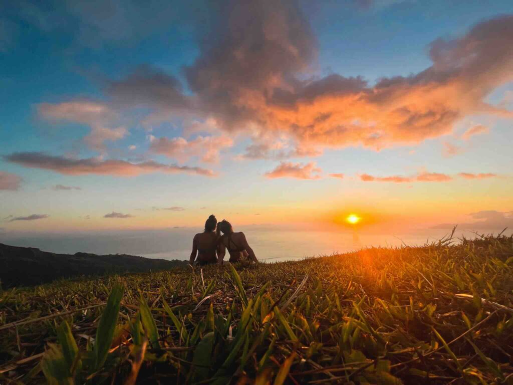 Eva and Manon at sunset on the heights of Tahiti overlooking the sea.