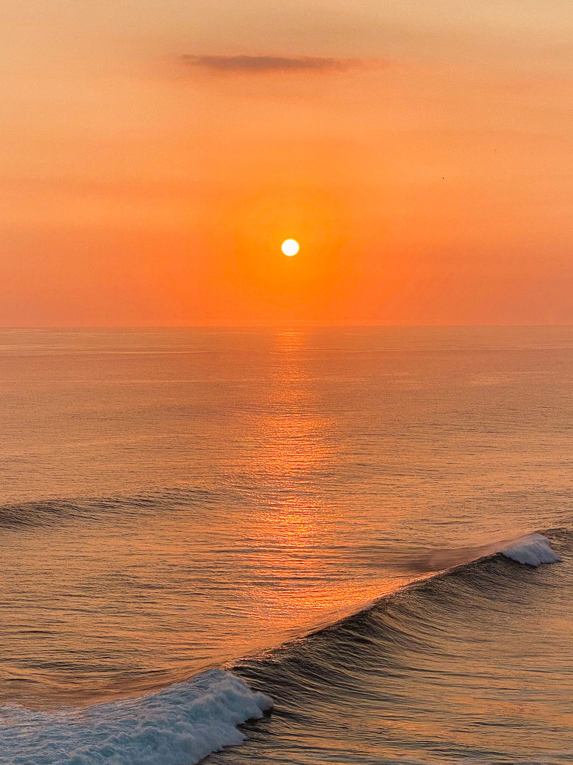 Sunset over the waves at Uluwatu, Bali.