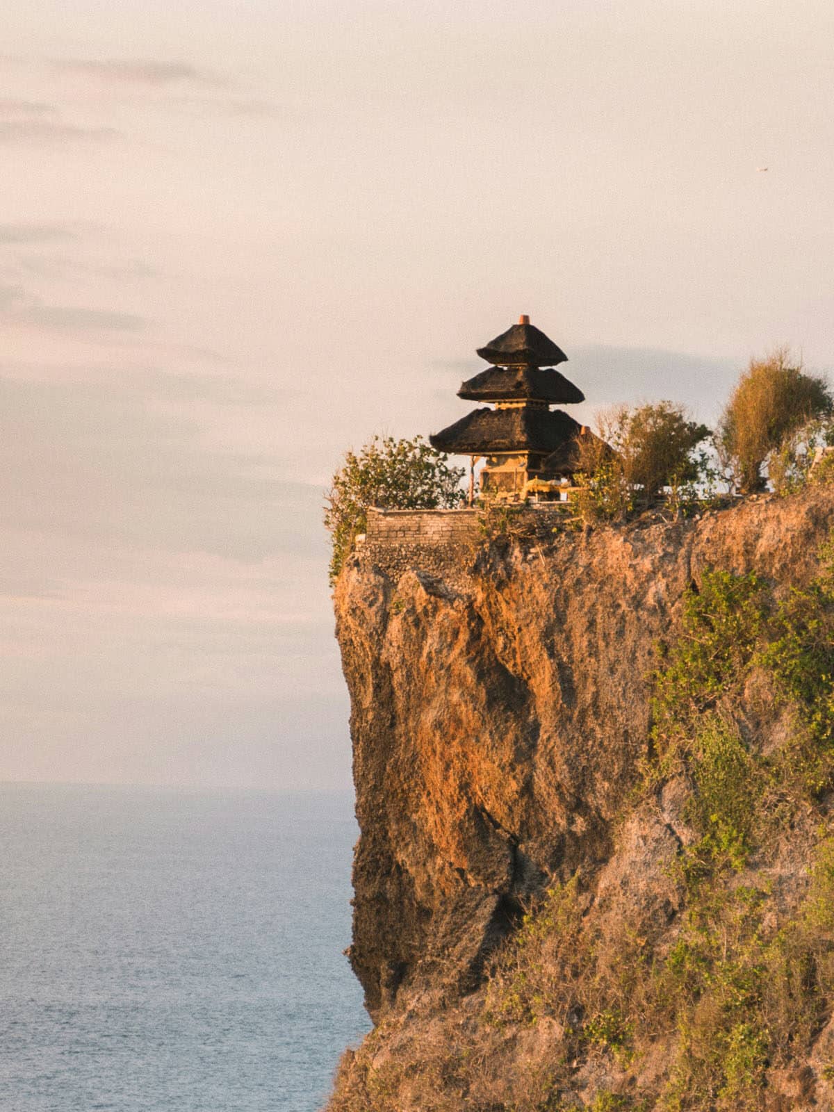 Temple d'Uluwatu perché sur une falaise au coucher de soleil, Bali.