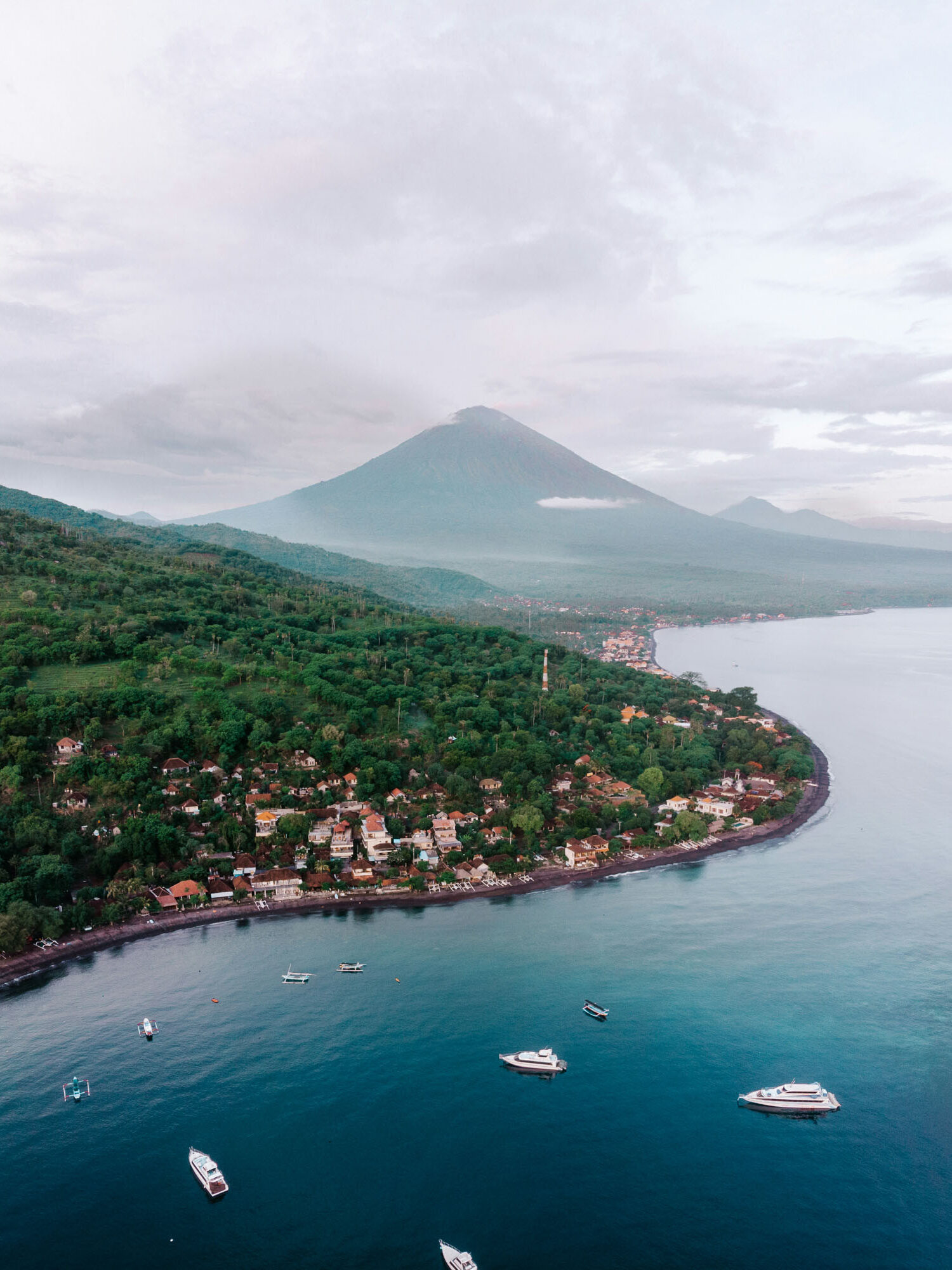 Aerial view of Amed, Bali, with Mount Agung and the ocean.